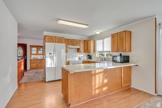 kitchen featuring light countertops, white appliances, under cabinet range hood, a sink, and a peninsula