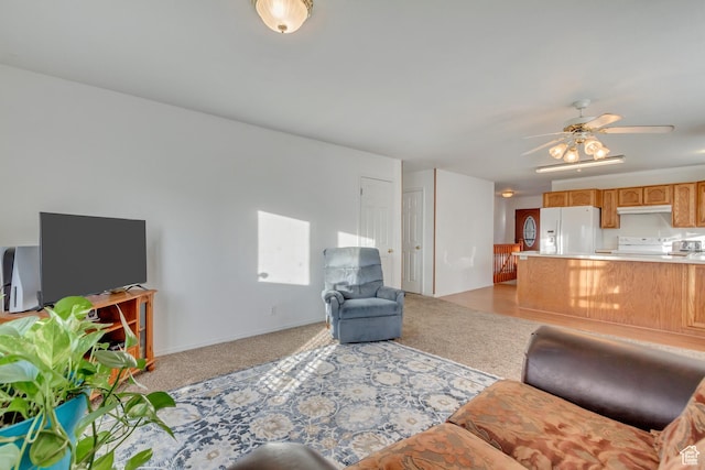 living area with light carpet and ceiling fan