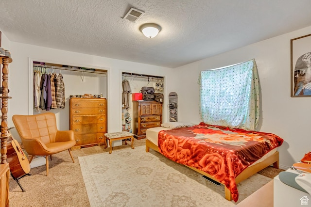 carpeted bedroom with a textured ceiling and visible vents