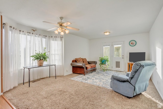 carpeted living room featuring a ceiling fan and visible vents