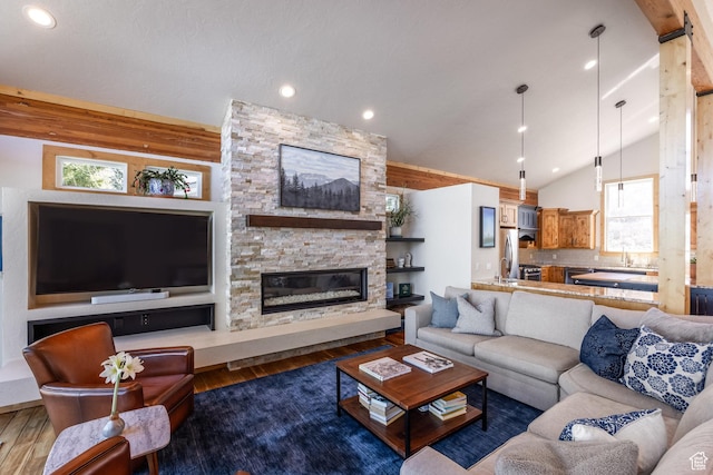 living room featuring plenty of natural light, lofted ceiling, wood finished floors, and a fireplace