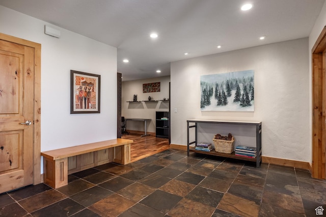 living area with baseboards, recessed lighting, and stone tile floors