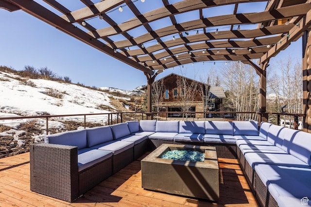 snow covered deck featuring a pergola and an outdoor living space with a fire pit
