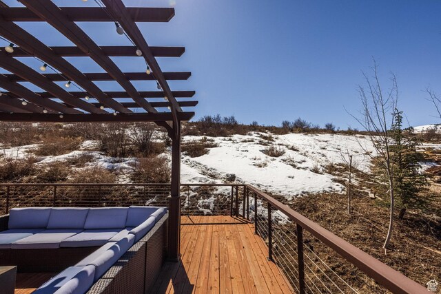 snow covered deck featuring outdoor lounge area and a pergola