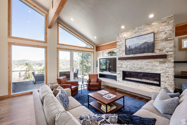 living room featuring a stone fireplace, beam ceiling, wood finished floors, high vaulted ceiling, and recessed lighting
