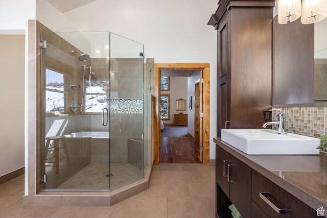 bathroom featuring backsplash, vanity, tile patterned flooring, and a stall shower