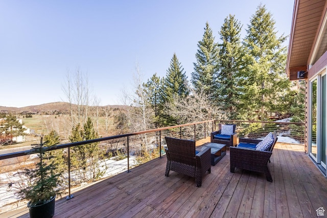 wooden deck with an outdoor living space and a mountain view