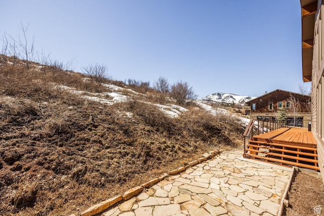 snow covered patio with a deck with mountain view