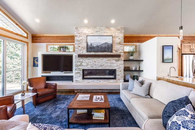 living area featuring recessed lighting, lofted ceiling with beams, wood finished floors, and a fireplace