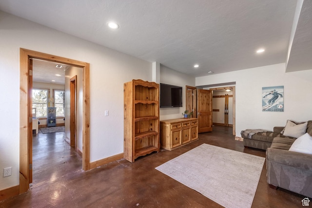 living room featuring baseboards, recessed lighting, and finished concrete flooring