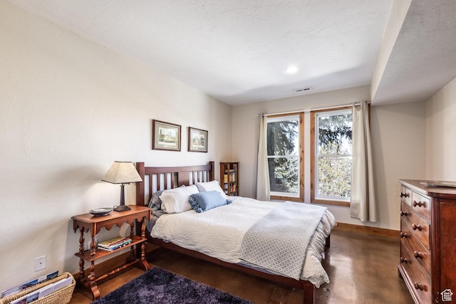 bedroom featuring concrete flooring, baseboards, and visible vents
