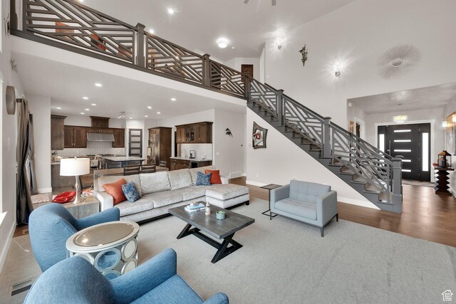 8165 S Willow Creek Cv E, Cottonwood Heights, UT 84093 - living room with stairs, a high ceiling, wood finished floors, baseboards, and recessed lighting