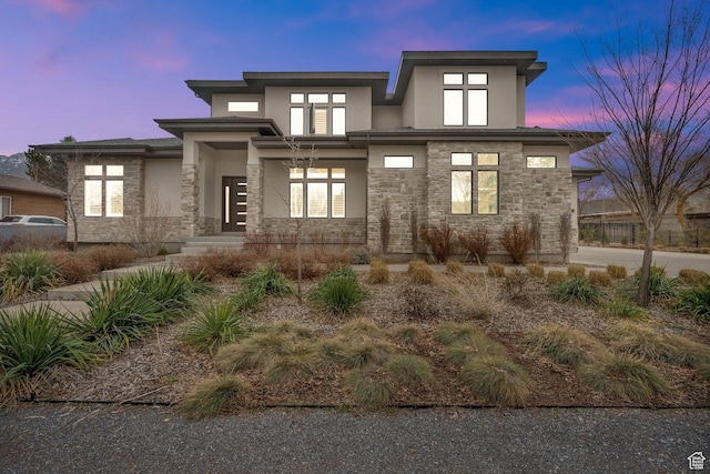prairie-style house featuring stone siding and stucco siding