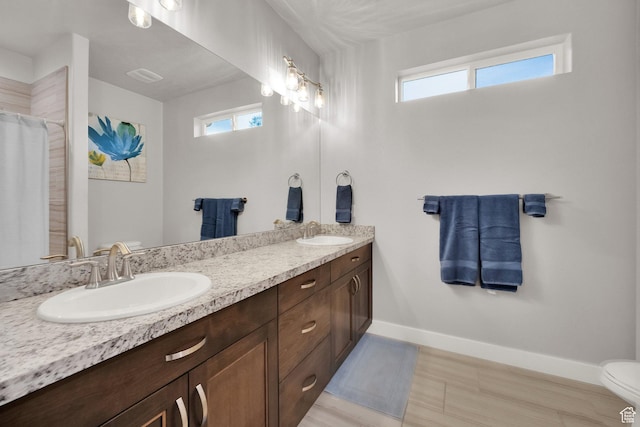 8165 S Willow Creek Cv E, Cottonwood Heights, UT 84093 - full bathroom with double vanity, a sink, toilet, and baseboards