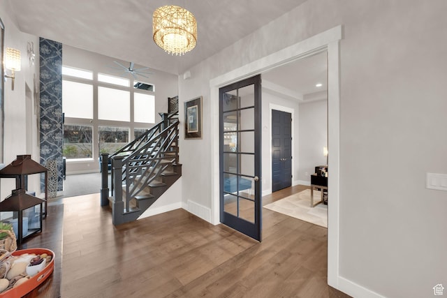 8165 S Willow Creek Cv E, Cottonwood Heights, UT 84093 - interior space featuring stairs, ceiling fan with notable chandelier, wood finished floors, and baseboards