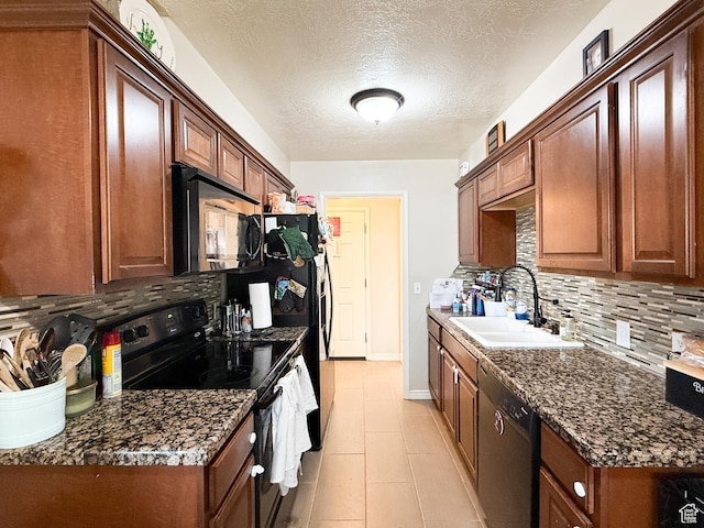 kitchen with a textured ceiling, black appliances, a sink, and tasteful backsplash