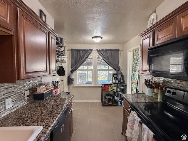 kitchen featuring decorative backsplash, a textured ceiling, baseboards, dark stone counters, and black appliances