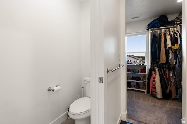 585 W 20 N, Hyrum, UT 84319 - bathroom featuring baseboards, visible vents, toilet, and a walk in closet