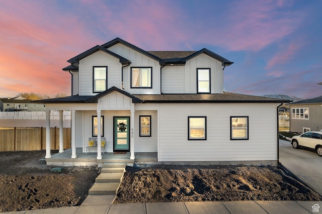 modern inspired farmhouse featuring fence, a porch, and board and batten siding