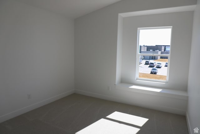 empty room featuring carpet and baseboards