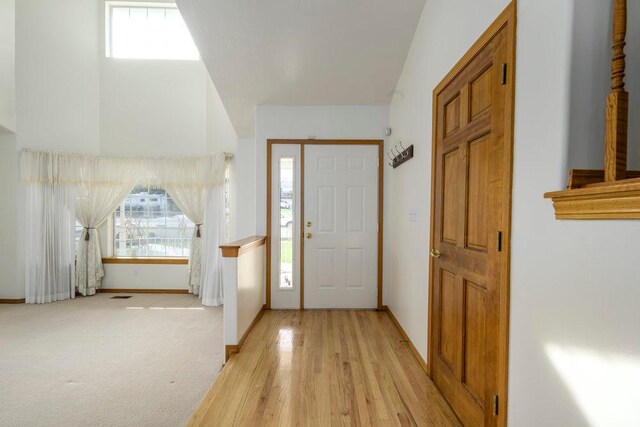 foyer featuring baseboards and light wood-type flooring