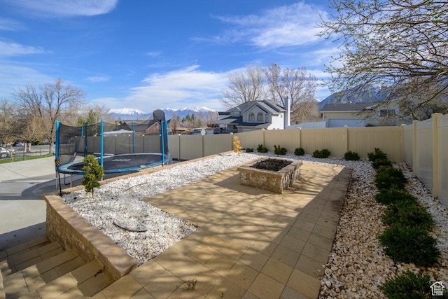 view of patio / terrace featuring a trampoline, a fenced backyard, and a mountain view