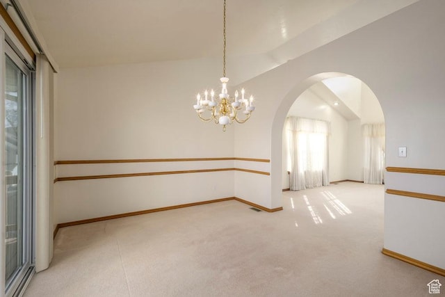 empty room with arched walkways, a chandelier, carpet floors, and baseboards
