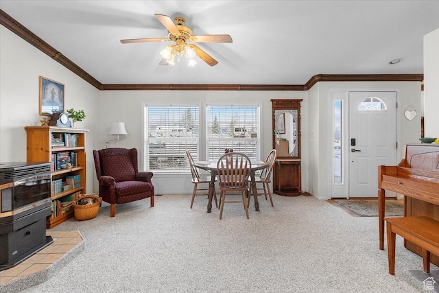 dining area featuring light colored carpet, ceiling fan, ornamental molding, and baseboards