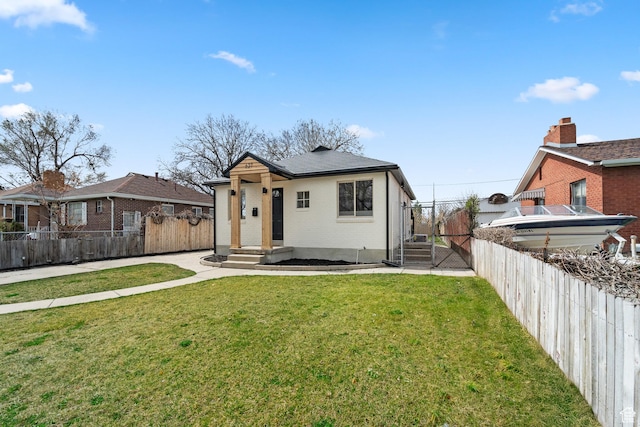 view of front of home featuring brick siding, a front yard, and fence