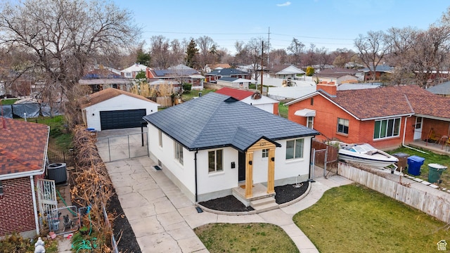 view of front of property with an outdoor structure, fence, a front lawn, a residential view, and a garage