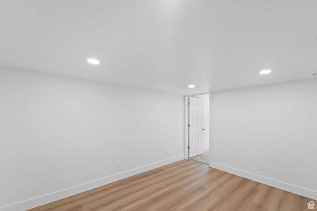 empty room with light wood-style flooring, baseboards, and recessed lighting