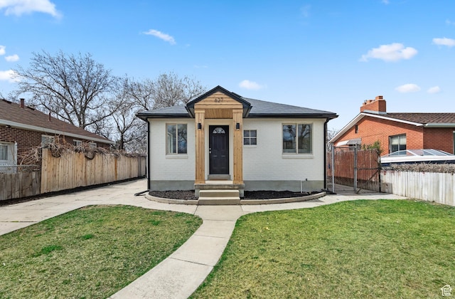 bungalow-style home featuring a front lawn, a gate, fence, and entry steps