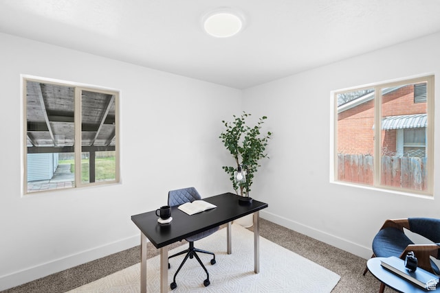 carpeted office space with plenty of natural light and baseboards