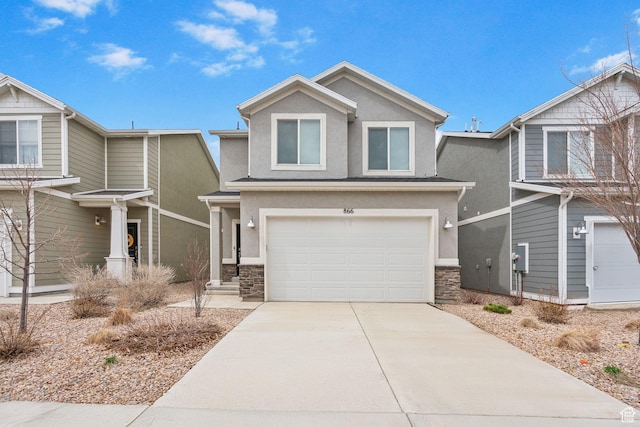 view of front of property featuring driveway, stucco siding, an attached garage, and stone siding