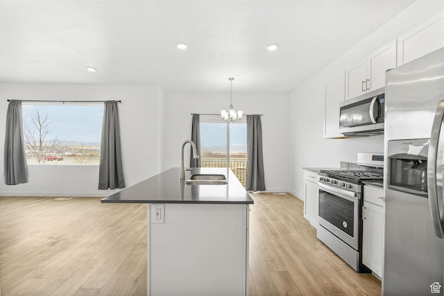 866 S Brubaker Way, Santaquin, UT 84655 - kitchen with stainless steel appliances, a chandelier, a center island with sink, white cabinets, and light wood-type flooring
