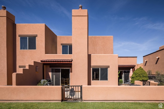 3418 E La Camino, Moab, UT 84532 - rear view of property with stucco siding, a chimney, and fence