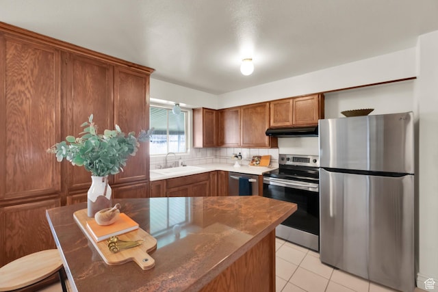 276 N 1100 E, Springville, UT 84663 - kitchen featuring stainless steel appliances, under cabinet range hood, a sink, light tile patterned flooring, and brown cabinetry