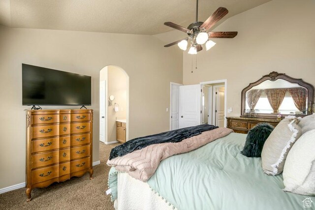 bedroom with baseboards, arched walkways, ensuite bath, high vaulted ceiling, and light colored carpet