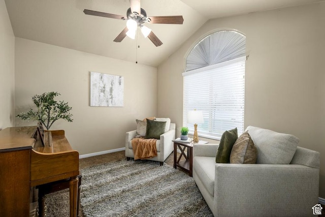 living area featuring carpet, baseboards, a ceiling fan, and vaulted ceiling