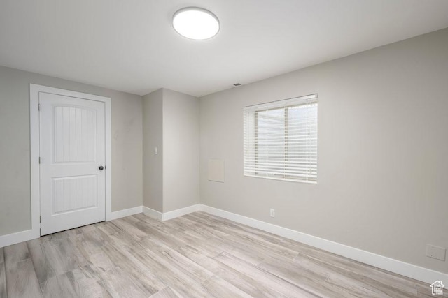 spare room featuring light wood-style flooring and baseboards