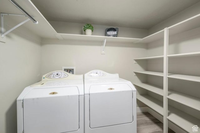 washroom featuring independent washer and dryer, laundry area, and wood finished floors