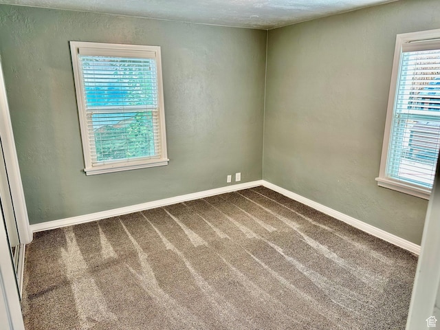 23 W 100 S, Payson, UT 84651 - spare room with baseboards, a textured wall, dark carpet, and a healthy amount of sunlight