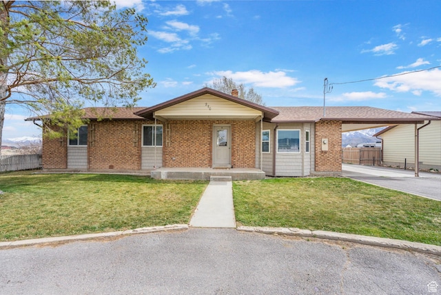 ranch-style house with roof with shingles, fence, driveway, a front lawn, and an attached carport
