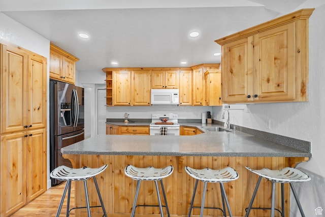 270 N 100 W, Goshen, UT 84633 - kitchen featuring a peninsula, light wood finished floors, white appliances, recessed lighting, and a sink