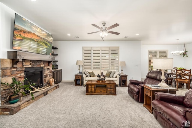 carpeted living area with recessed lighting, baseboards, ceiling fan with notable chandelier, and a fireplace