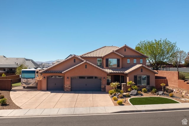mediterranean / spanish home featuring a tiled roof, a garage, fence, concrete driveway, and stucco siding