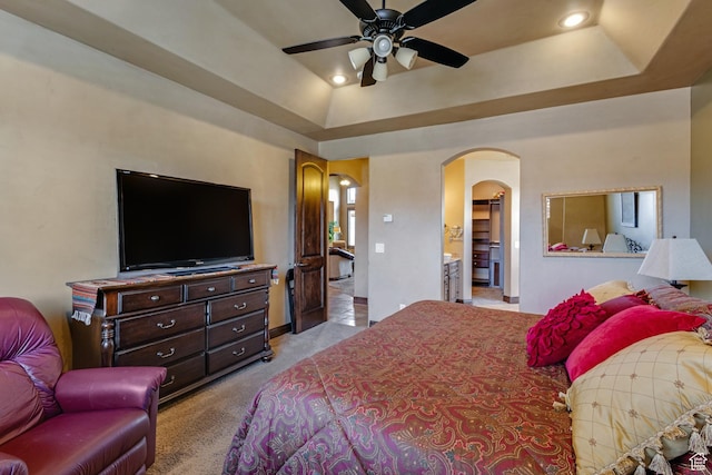 428 N Northstar Dr, St George, UT 84770 - bedroom with a tray ceiling, arched walkways, recessed lighting, light colored carpet, and ensuite bath
