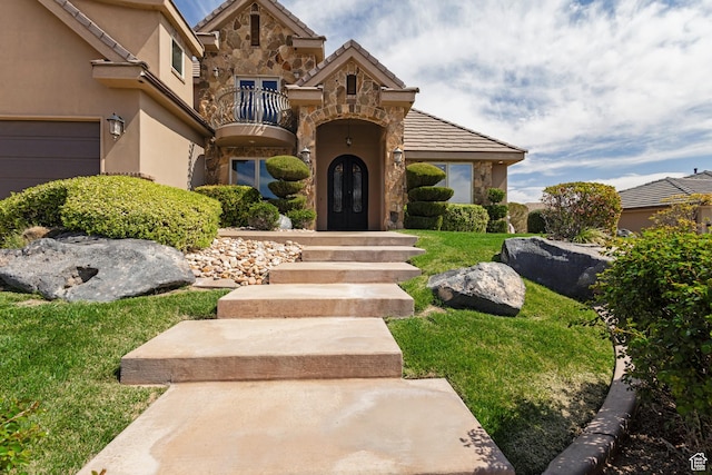 428 N Northstar Dr, St George, UT 84770 - view of front of property featuring a balcony, stucco siding, french doors, stone siding, and a garage