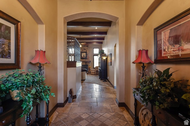 428 N Northstar Dr, St George, UT 84770 - hallway with arched walkways, baseboards, stone tile floors, and beamed ceiling