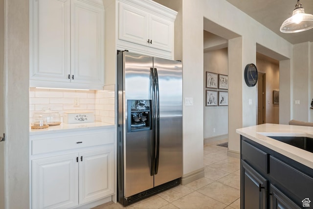 2653 Rio Lobo Dr, St George, UT 84770 - kitchen with light tile patterned flooring, white cabinets, stainless steel fridge, tasteful backsplash, and pendant lighting